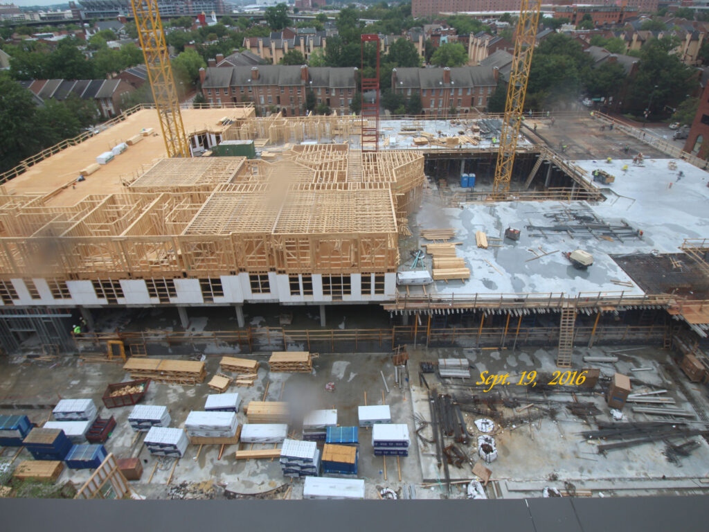 Historic Proportions: Banner Hill Aerial progress view of Banner Hill multi-family apartment construction showing panelized wall installation over a concrete podium deck by Modu Tech in Baltimore.